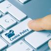 A finger shown pressing a button on a keyboard that says &quot;Cookie Policy.&quot;